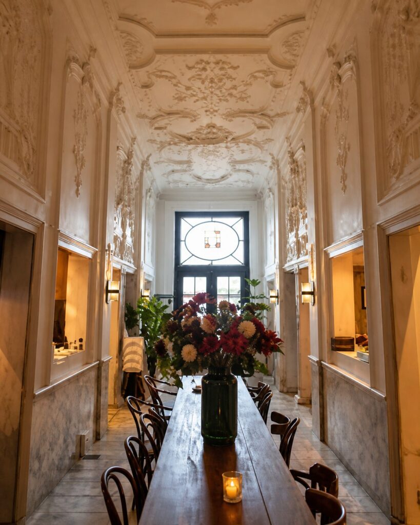 De gang met lange tafel en bloemen